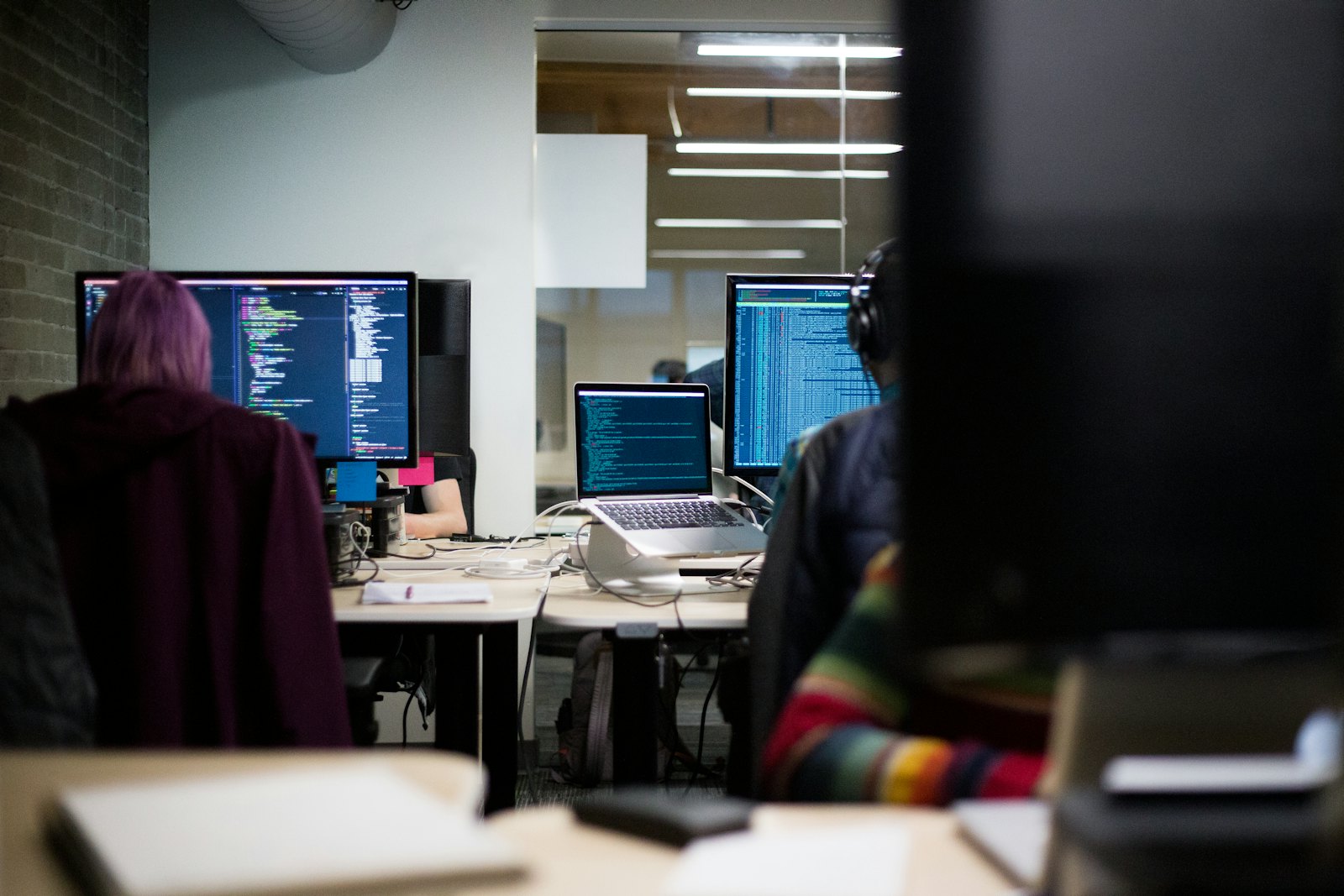 A row of workstation monitors in a development office